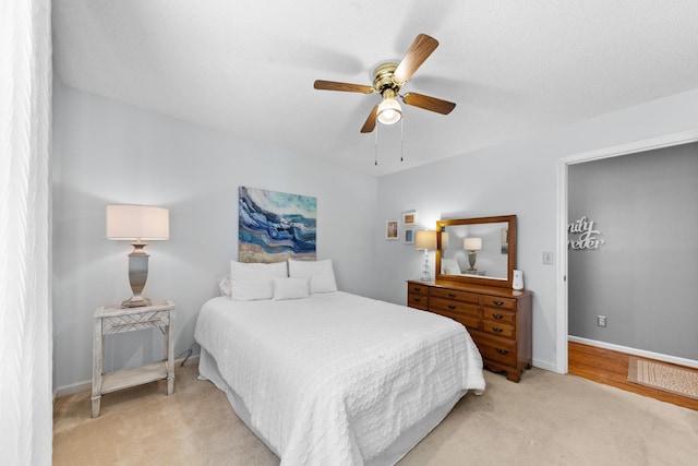 bedroom featuring light carpet, visible vents, baseboards, and a ceiling fan