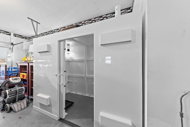 interior space featuring finished concrete flooring and a textured ceiling