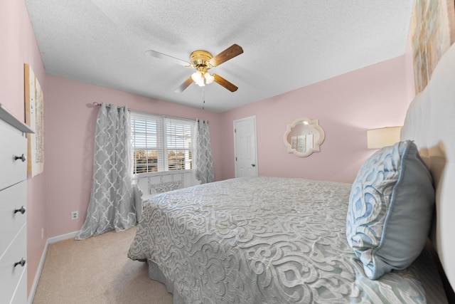 bedroom featuring a textured ceiling, ceiling fan, baseboards, and light colored carpet