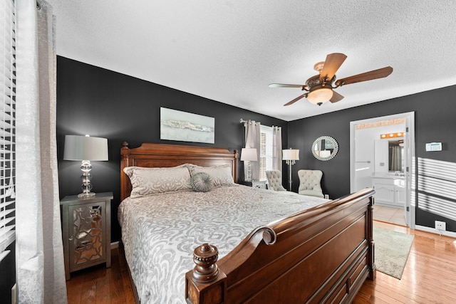 bedroom featuring a ceiling fan, a textured ceiling, light wood finished floors, and ensuite bathroom