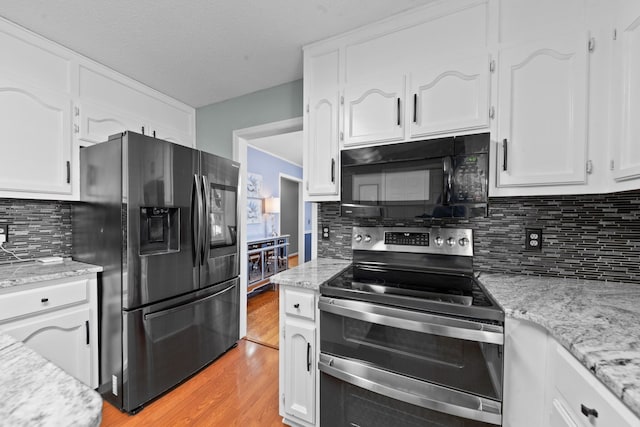 kitchen featuring stainless steel appliances, light wood finished floors, backsplash, and white cabinets