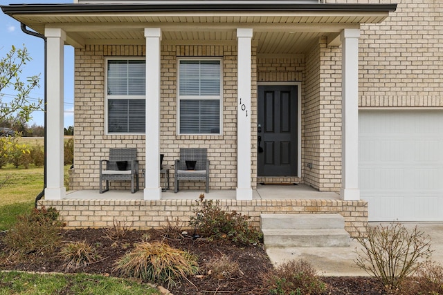 entrance to property with covered porch, an attached garage, and crawl space