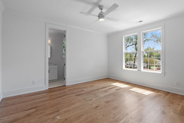 unfurnished room with baseboards, light wood finished floors, visible vents, and a ceiling fan