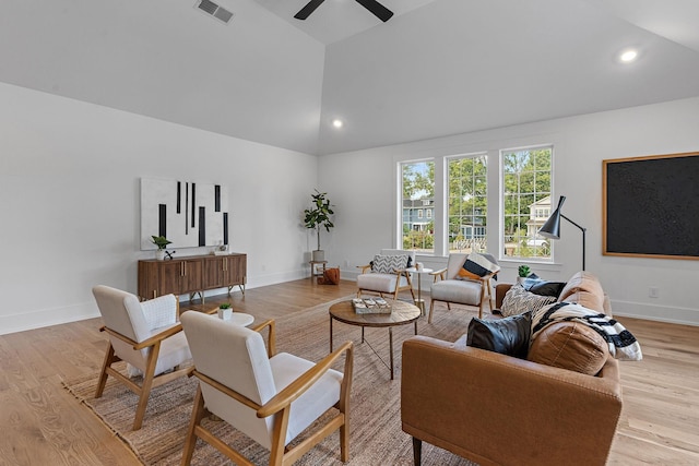 living area featuring visible vents, baseboards, light wood-style flooring, high vaulted ceiling, and recessed lighting