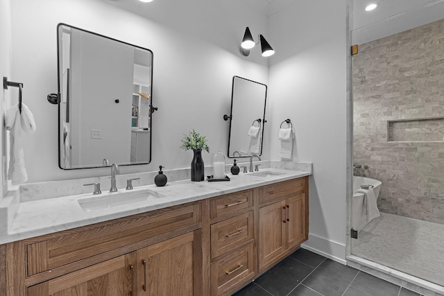 bathroom featuring double vanity, a soaking tub, a sink, and tile patterned floors