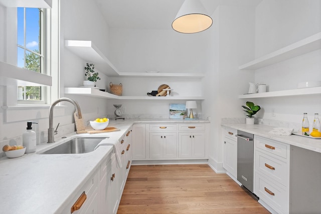 kitchen with open shelves, light wood finished floors, a sink, and white cabinetry