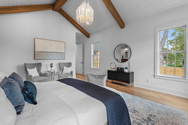 bedroom featuring baseboards, visible vents, wood finished floors, vaulted ceiling with beams, and a chandelier