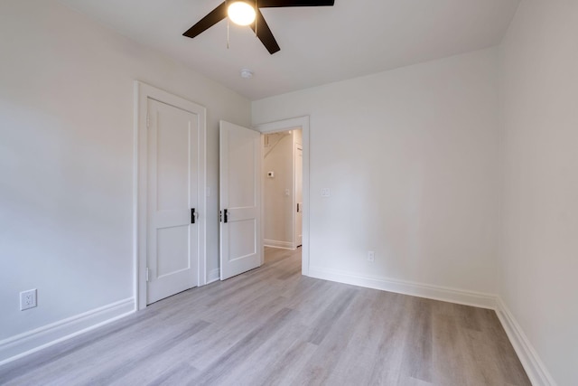 spare room with a ceiling fan, baseboards, and wood finished floors