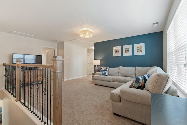 carpeted living area featuring visible vents and baseboards