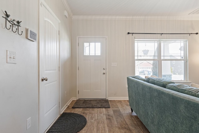 foyer entrance featuring visible vents, baseboards, wood finished floors, and ornamental molding