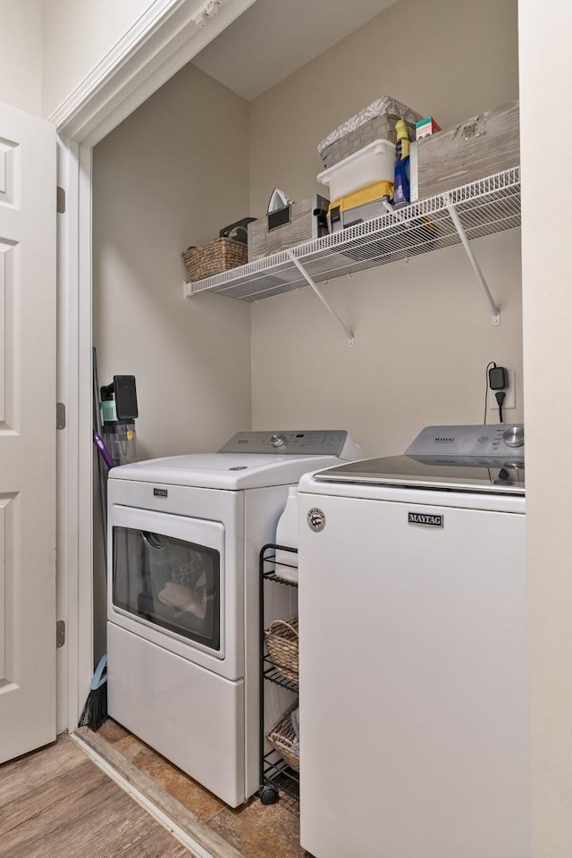 laundry room featuring laundry area, wood finished floors, and washer and clothes dryer