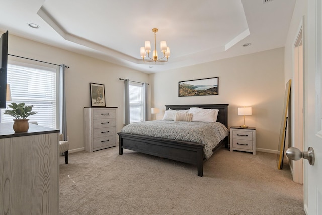 bedroom with a tray ceiling, light carpet, and a notable chandelier