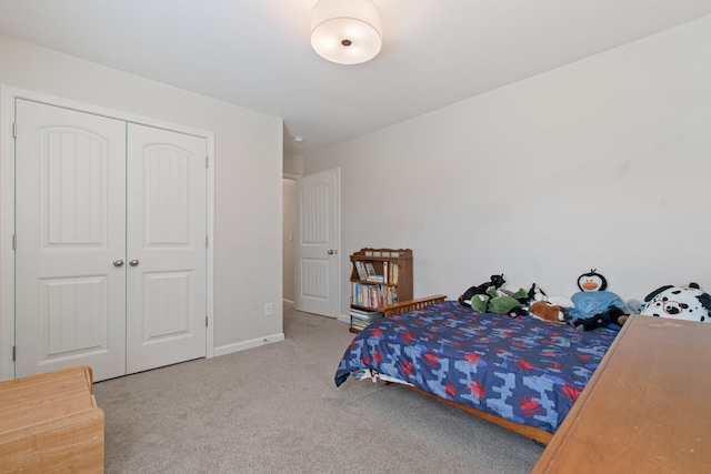 carpeted bedroom featuring a closet and baseboards