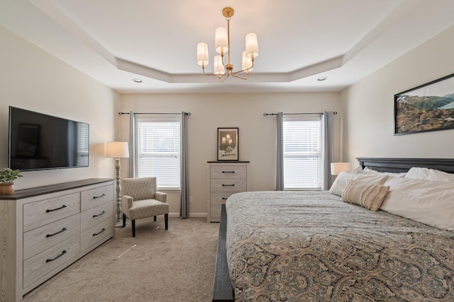 bedroom featuring a tray ceiling, multiple windows, and light colored carpet