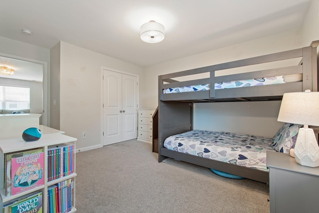 bedroom with a closet, baseboards, and carpet flooring