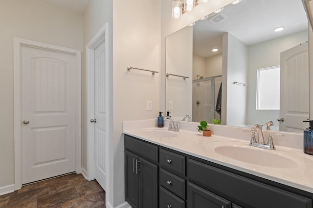 full bathroom featuring double vanity, visible vents, a shower stall, and a sink