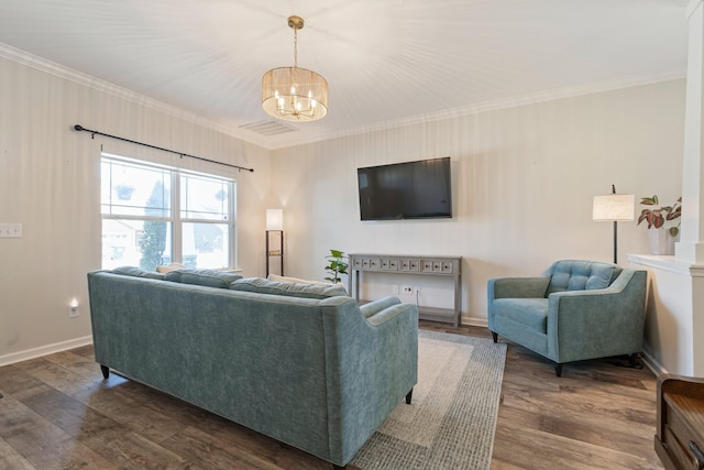 living room featuring an inviting chandelier, crown molding, dark wood-style floors, and baseboards