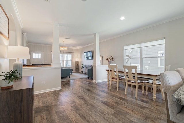 dining space with baseboards, crown molding, ornate columns, and wood finished floors