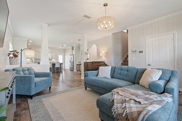 living room featuring visible vents, ornamental molding, stairway, and wood finished floors