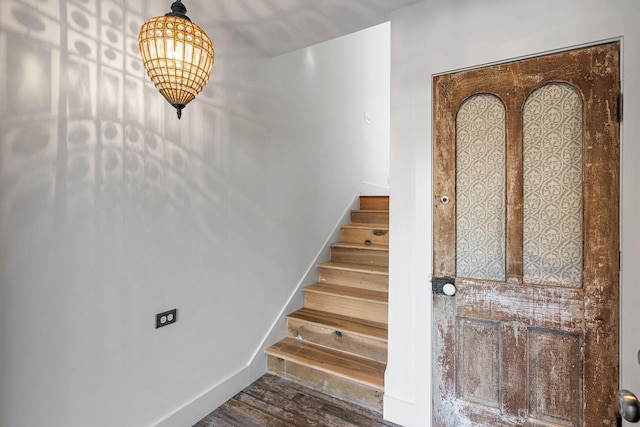 staircase with baseboards and wood finished floors