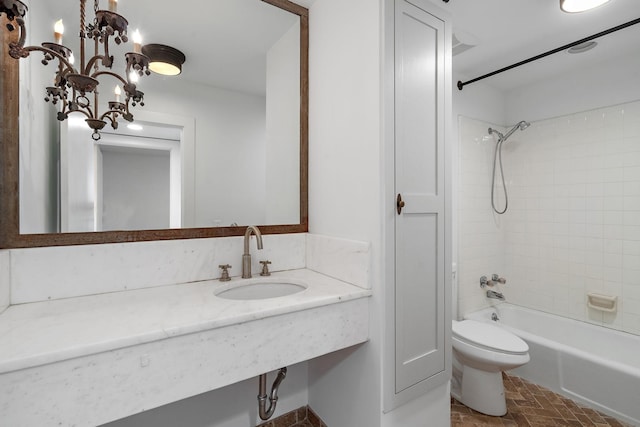 bathroom with washtub / shower combination, a sink, and toilet