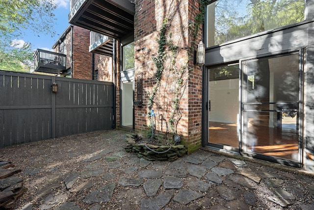 doorway to property with fence and brick siding