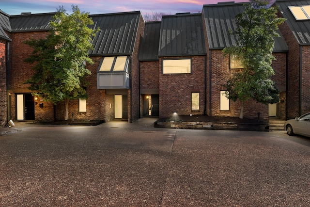 view of front of property with a standing seam roof, metal roof, and brick siding