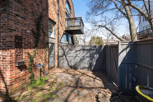 view of yard featuring fence and a balcony