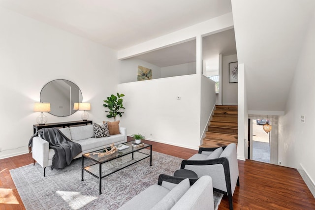 living room with baseboards, stairs, beam ceiling, and wood finished floors