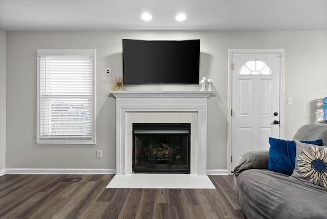 living room with a tiled fireplace, baseboards, wood finished floors, and recessed lighting