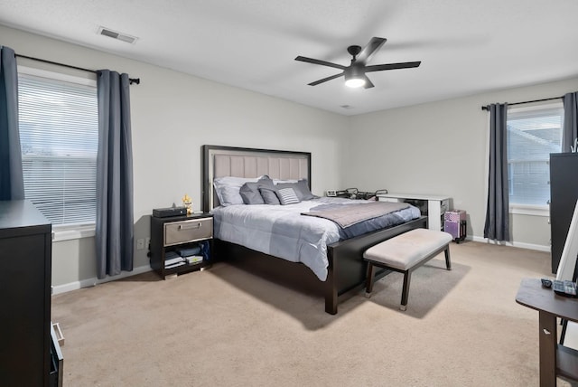 bedroom with light carpet, baseboards, visible vents, and a ceiling fan