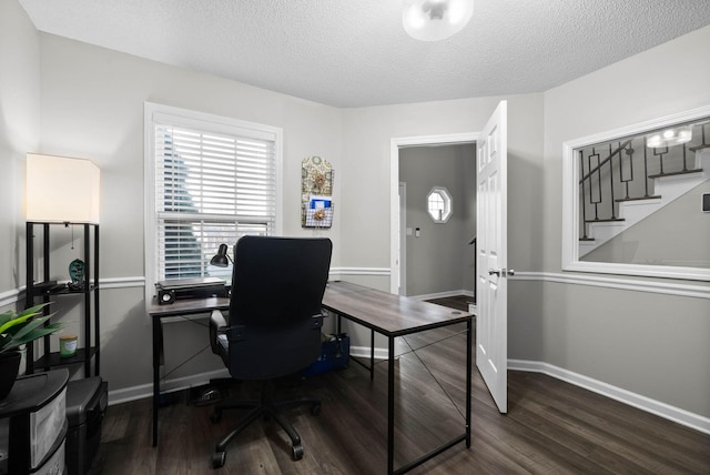 office area with a textured ceiling, baseboards, and wood finished floors