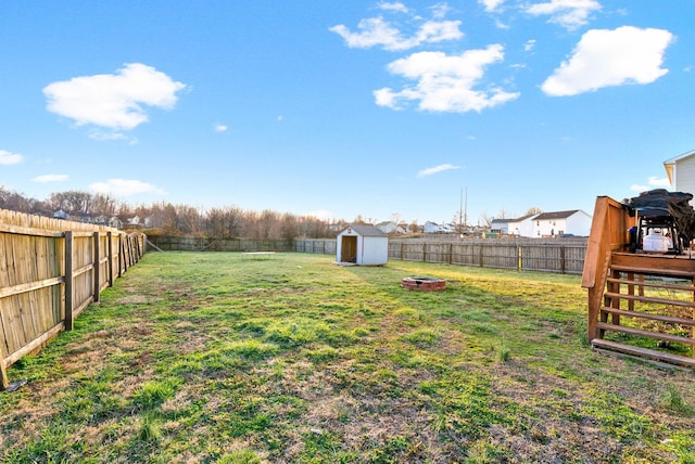 view of yard with a shed, a fenced backyard, and an outbuilding