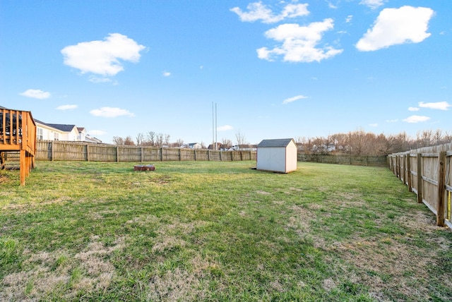 view of yard featuring a fenced backyard, an outdoor structure, and a shed