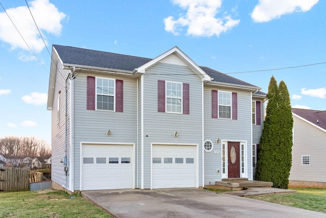 view of front of home featuring driveway, an attached garage, and fence