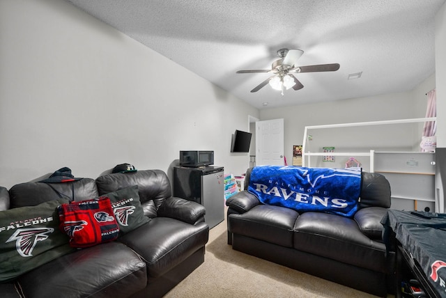 living room featuring carpet floors, a ceiling fan, visible vents, and a textured ceiling