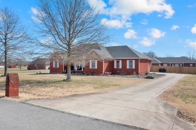 view of front of home with brick siding, a shingled roof, crawl space, fence, and a front lawn