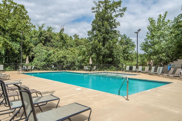 community pool featuring fence and a patio