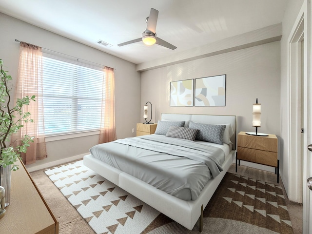 carpeted bedroom featuring ceiling fan, visible vents, and baseboards