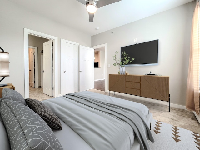 bedroom featuring ceiling fan, baseboards, and light colored carpet