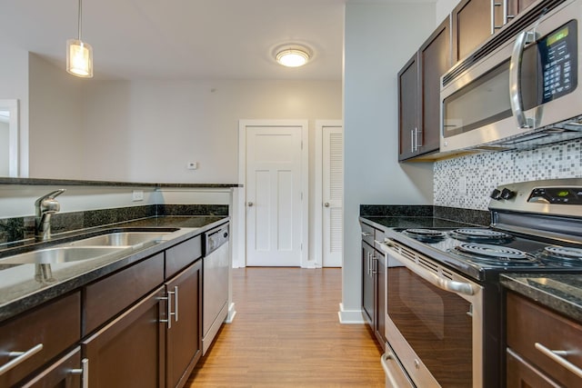 kitchen with appliances with stainless steel finishes, a sink, and dark brown cabinetry