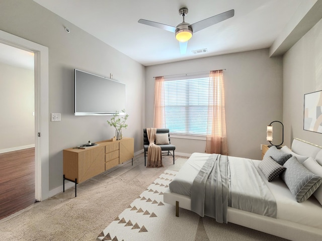 bedroom with baseboards, visible vents, a ceiling fan, and light colored carpet