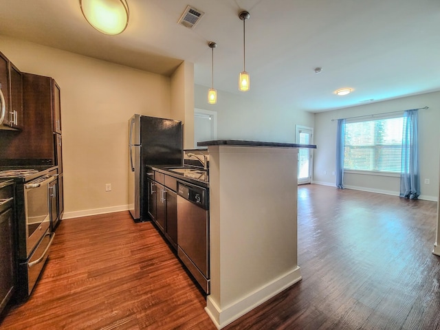 kitchen with dark countertops, visible vents, appliances with stainless steel finishes, dark wood-type flooring, and a sink