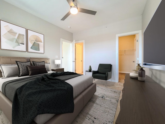 bedroom with a closet, baseboards, a walk in closet, and a ceiling fan