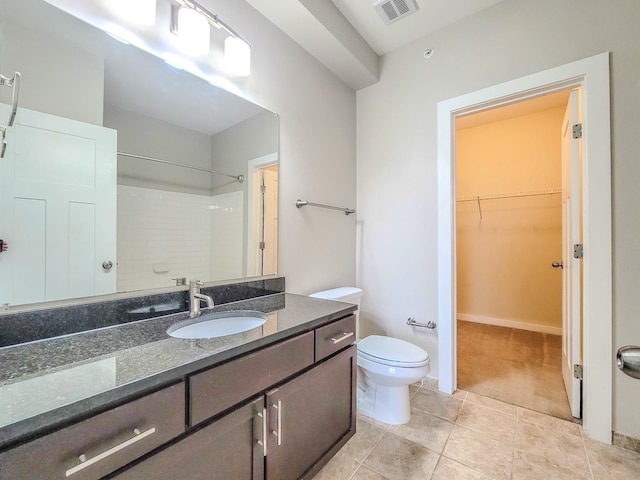 bathroom with toilet, vanity, visible vents, a walk in closet, and walk in shower