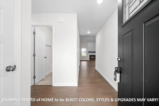 entrance foyer with a lit fireplace, baseboards, wood finished floors, and recessed lighting