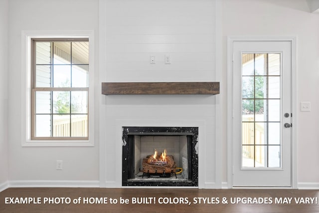 room details featuring a lit fireplace and baseboards