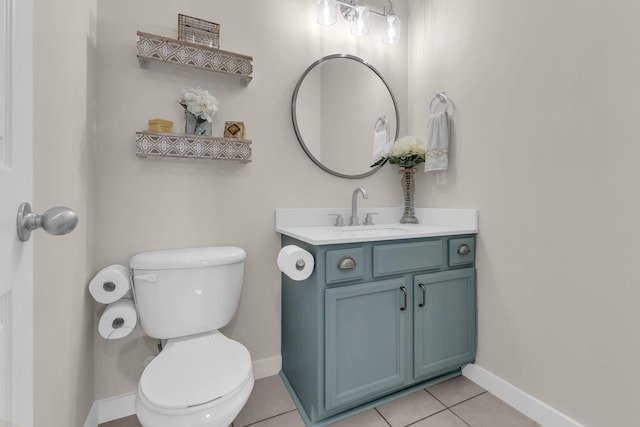 half bath with tile patterned flooring, vanity, toilet, and baseboards