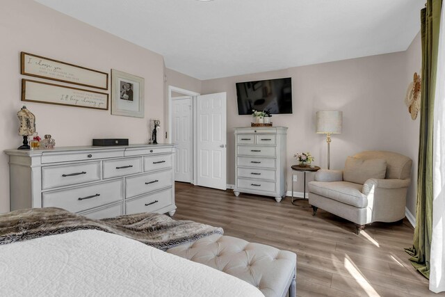 bedroom with baseboards and wood finished floors