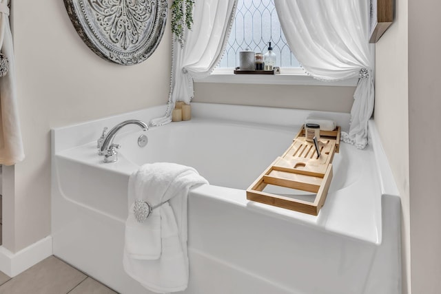 bathroom with tile patterned floors and a bath